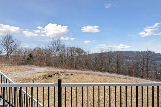 exterior space with a forest view and fence