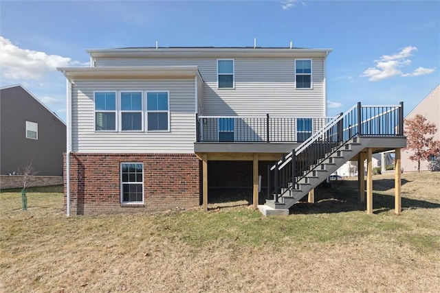 back of property featuring a deck, brick siding, a lawn, and stairway