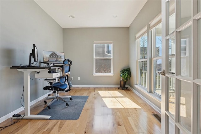 office area with wood finished floors, visible vents, and baseboards