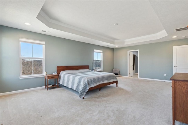 bedroom featuring a raised ceiling, visible vents, and baseboards