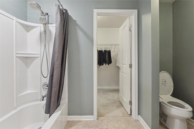 bathroom featuring baseboards, toilet, tile patterned floors, a walk in closet, and shower / bath combo with shower curtain