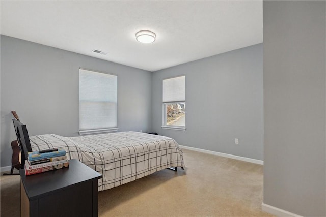 bedroom featuring light colored carpet, visible vents, and baseboards