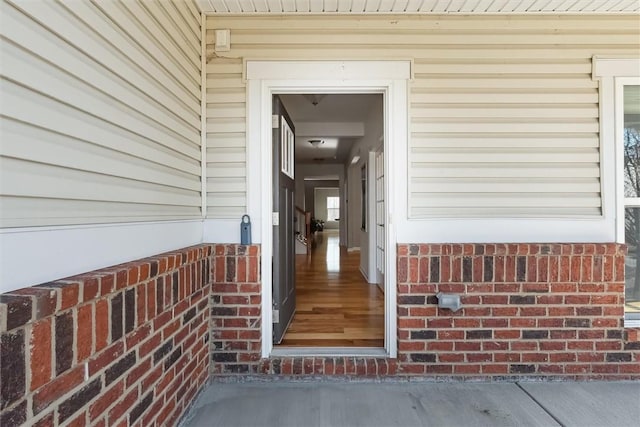 doorway to property featuring brick siding