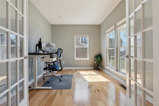 home office featuring visible vents, baseboards, wood finished floors, and french doors