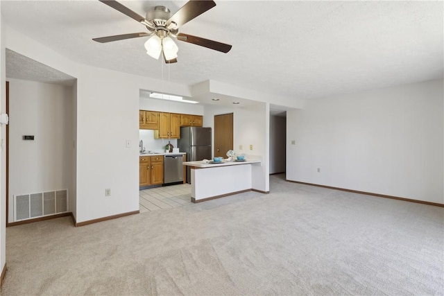 unfurnished living room featuring baseboards, visible vents, a ceiling fan, light colored carpet, and a sink