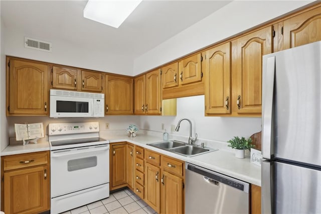 kitchen featuring light tile patterned floors, visible vents, stainless steel appliances, light countertops, and a sink