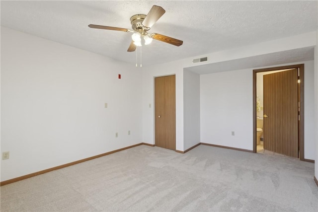 carpeted spare room with a ceiling fan, baseboards, visible vents, and a textured ceiling