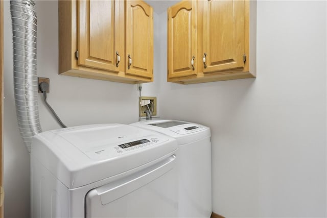 washroom with cabinet space and washer and dryer