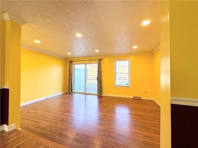 unfurnished room featuring baseboards, ornamental molding, and wood finished floors