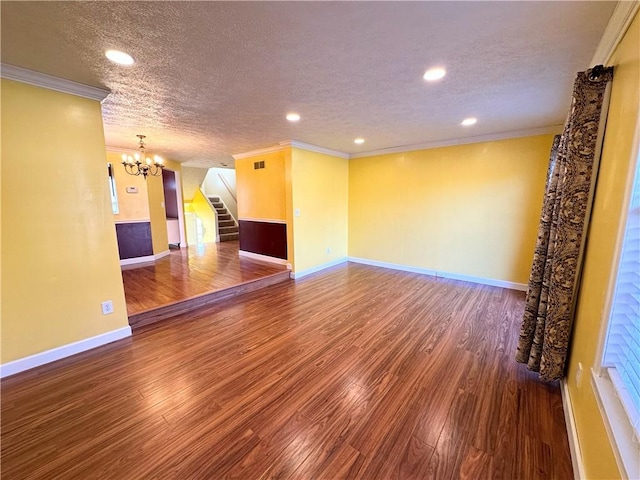 unfurnished room with stairs, ornamental molding, a textured ceiling, and wood finished floors