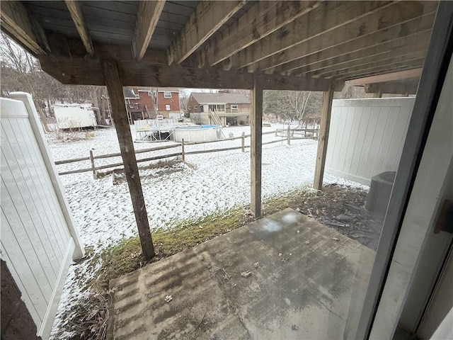 snow covered patio featuring a balcony