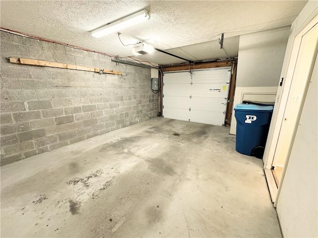 garage featuring concrete block wall and a garage door opener