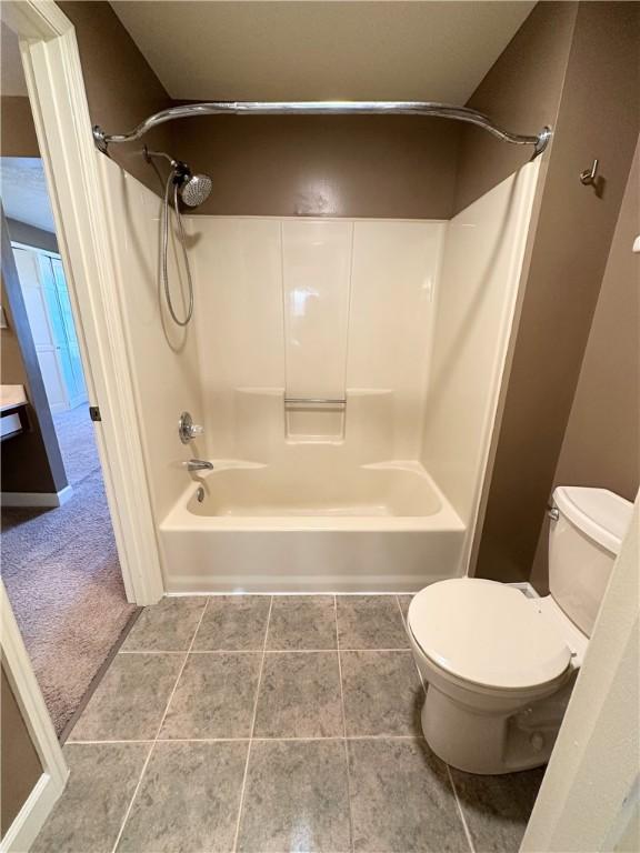 full bath with tile patterned flooring, shower / bathing tub combination, and toilet