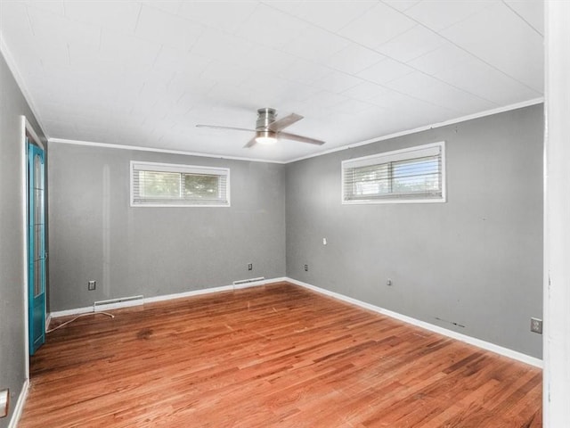 empty room featuring a healthy amount of sunlight, ornamental molding, and wood finished floors