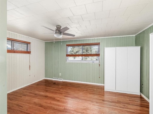 unfurnished bedroom featuring wood finished floors, visible vents, and baseboards