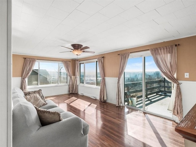 living area featuring ceiling fan, ornamental molding, and wood finished floors