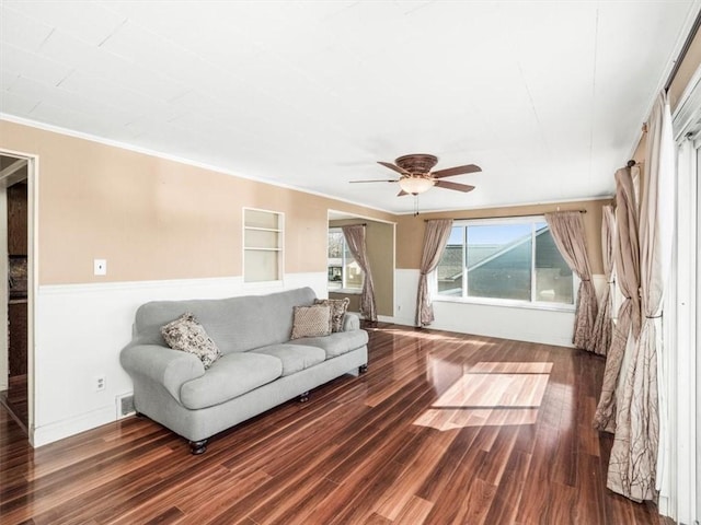 living room featuring ornamental molding, visible vents, ceiling fan, and wood finished floors