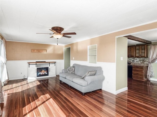 unfurnished living room with a ceiling fan, a glass covered fireplace, baseboards, and wood finished floors