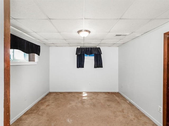 basement with baseboards, visible vents, and a drop ceiling