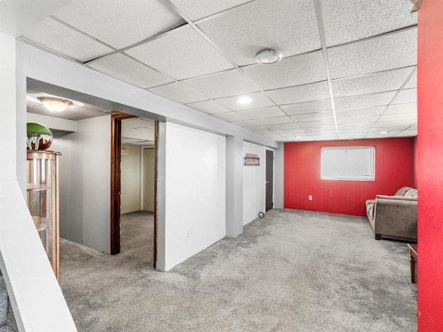 below grade area with a drop ceiling and carpet flooring