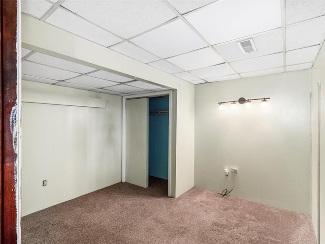 unfurnished bedroom with visible vents, carpet floors, a closet, and a paneled ceiling