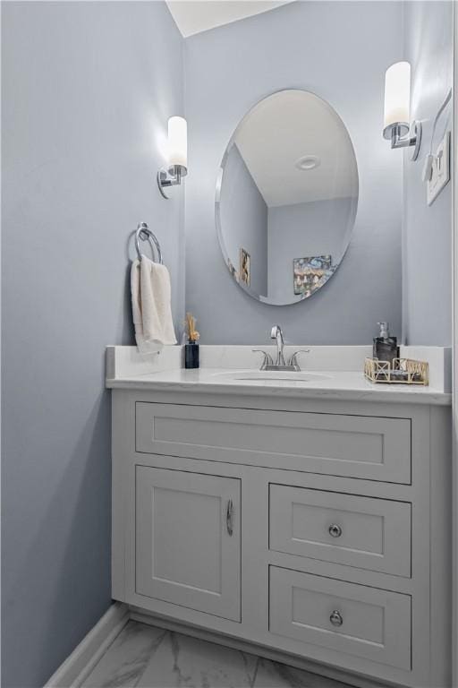 bathroom with baseboards, marble finish floor, and vanity