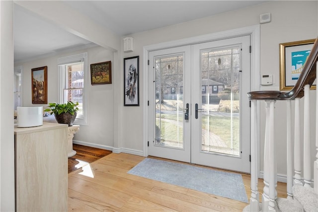 entryway featuring stairway, french doors, light wood-type flooring, and baseboards