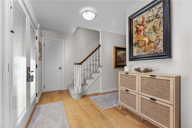 foyer featuring stairway, baseboards, and light wood-type flooring