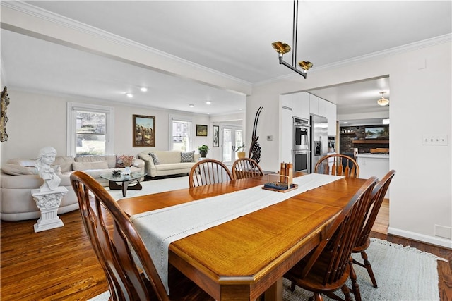 dining room with a wealth of natural light, dark wood-type flooring, and ornamental molding