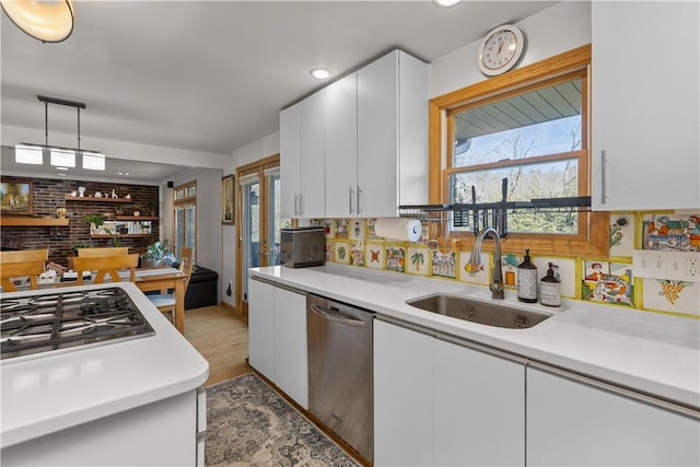 kitchen featuring appliances with stainless steel finishes, light countertops, and a sink