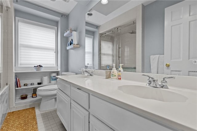 full bathroom featuring tile patterned flooring, double vanity, toilet, and a sink