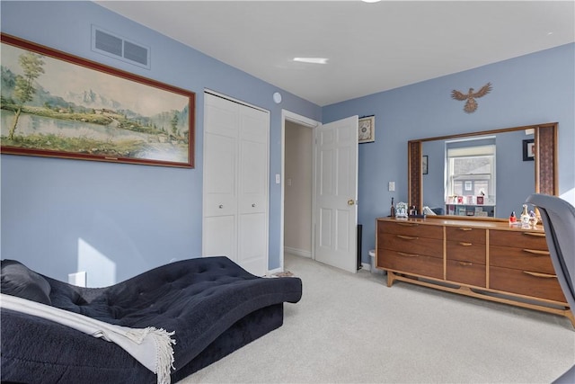 bedroom featuring baseboards, visible vents, a closet, and light carpet