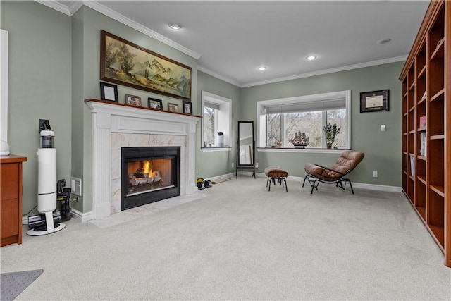 living area featuring ornamental molding, baseboards, carpet, and a premium fireplace