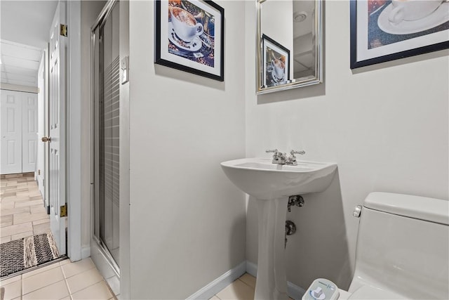 full bathroom with tile patterned floors, baseboards, toilet, and a stall shower