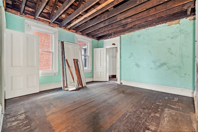 unfurnished room featuring baseboards and wood-type flooring