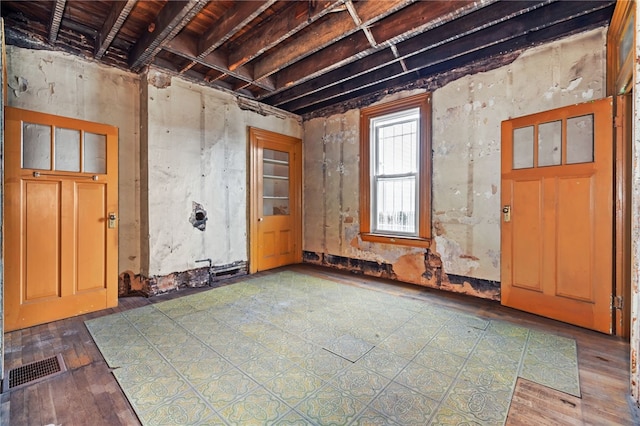 empty room featuring visible vents and hardwood / wood-style floors