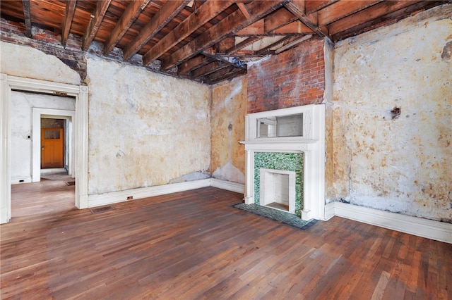 below grade area featuring a tiled fireplace, visible vents, baseboards, and hardwood / wood-style flooring