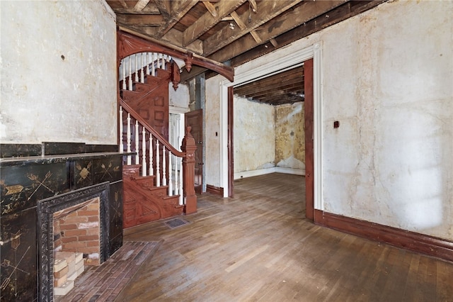 interior space with visible vents, a fireplace with flush hearth, and wood finished floors