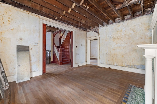 unfurnished living room featuring hardwood / wood-style floors and stairs