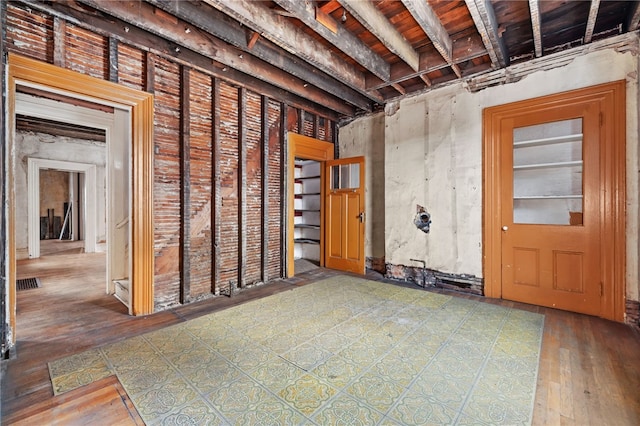 basement featuring visible vents and hardwood / wood-style flooring