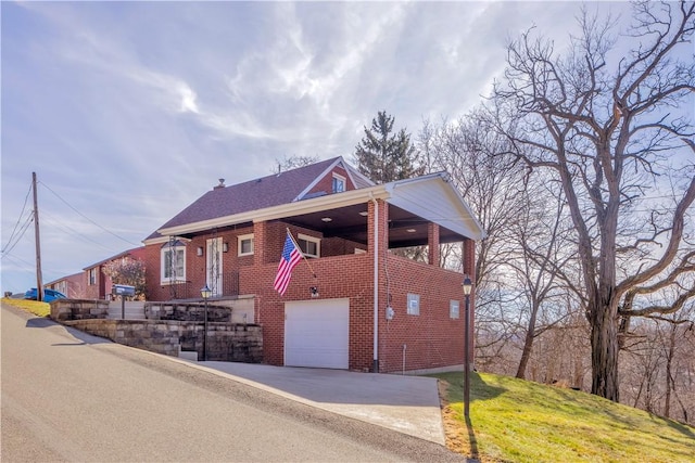 view of front facade featuring a garage, driveway, and brick siding