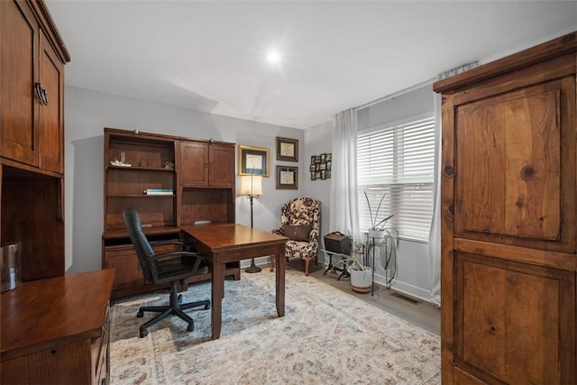 office area featuring light wood finished floors and visible vents