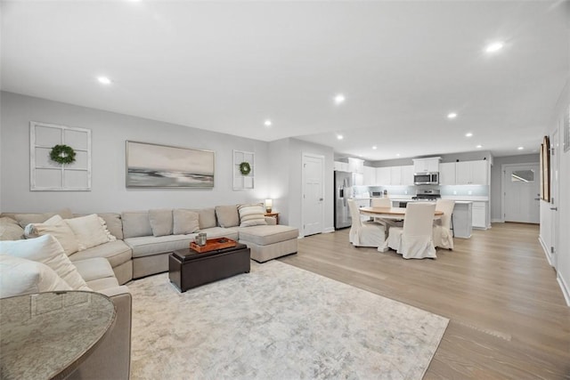 living area with light wood-style flooring and recessed lighting