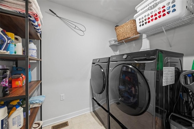 laundry room featuring laundry area, baseboards, visible vents, tile patterned floors, and independent washer and dryer