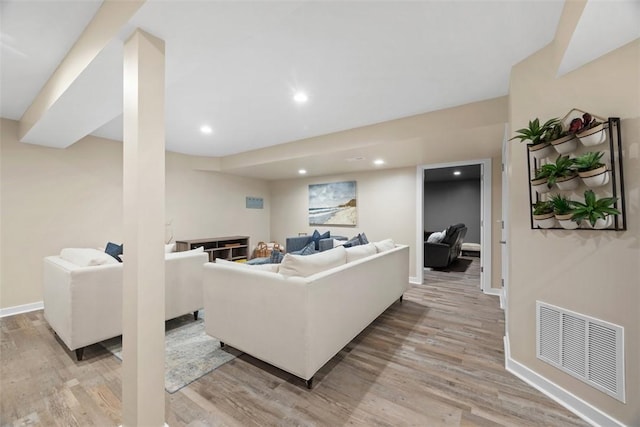 living area featuring light wood-style flooring, recessed lighting, visible vents, and baseboards