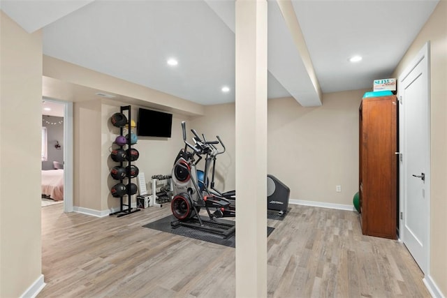 exercise room with light wood-type flooring, baseboards, and recessed lighting