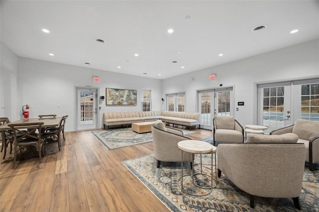 living area featuring visible vents, french doors, light wood-style flooring, and recessed lighting