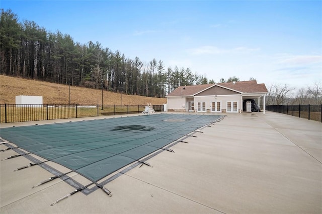 community pool featuring french doors, a patio area, and fence