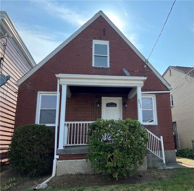 view of front of home with covered porch and brick siding