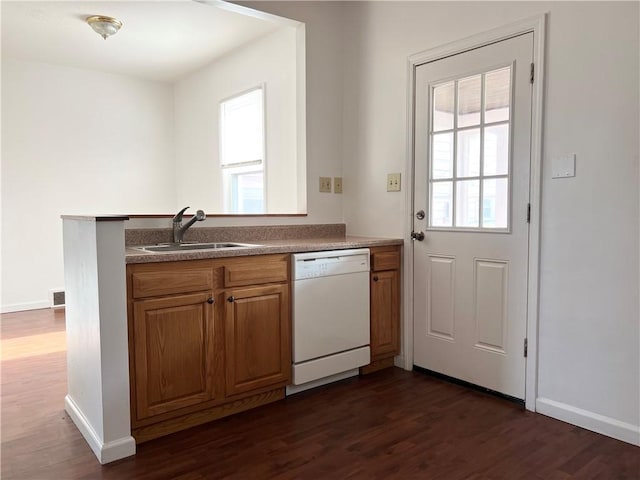 kitchen featuring dark wood-style floors, brown cabinets, visible vents, a sink, and dishwasher